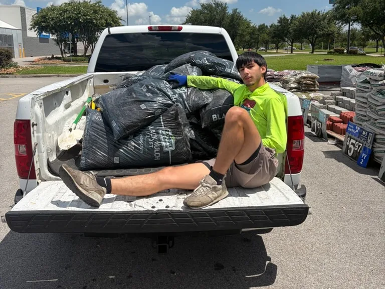 Truck bed loaded with bags of mulch on a supply run